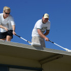 Tripler Army Medical CenterÕs Sgt. Jessica Houfek and Spc. Christopher Monteith lay down a special white coating on a Moanalua Elementary School portable classroom to help keep the classroom cool, June 13, 209. Along with 21 other TAMC Soldiers and family members, they volunteered their morning to provide sweat, elbow equity and camaraderie to cool down a total of five classrooms and to install two playball basket shoot equipment, as part of U.S. Army Garrison-Hawaii's Partnership of Ohana program.