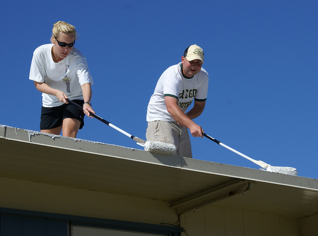 Tripler Army Medical CenterÕs Sgt. Jessica Houfek and Spc. Christopher Monteith lay down a special white coating on a Moanalua Elementary School portable classroom to help keep the classroom cool, June 13, 209. Along with 21 other TAMC Soldiers and family members, they volunteered their morning to provide sweat, elbow equity and camaraderie to cool down a total of five classrooms and to install two playball basket shoot equipment, as part of U.S. Army Garrison-Hawaii's Partnership of Ohana program.