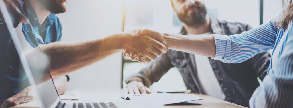 how to ask for sponsorship - Business partnership handshake concept.Photo two coworkers handshaking process.Successful deal after great meeting.Horizontal, blurred background.Wide.