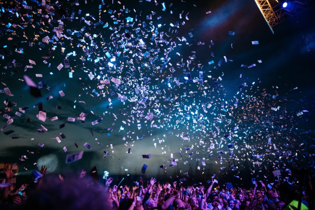 participating in a giving event: image of crowd cheering with confetti falling on them